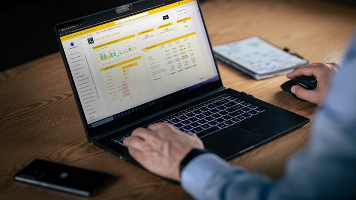 A Power BI financial report open on a laptop during a training session